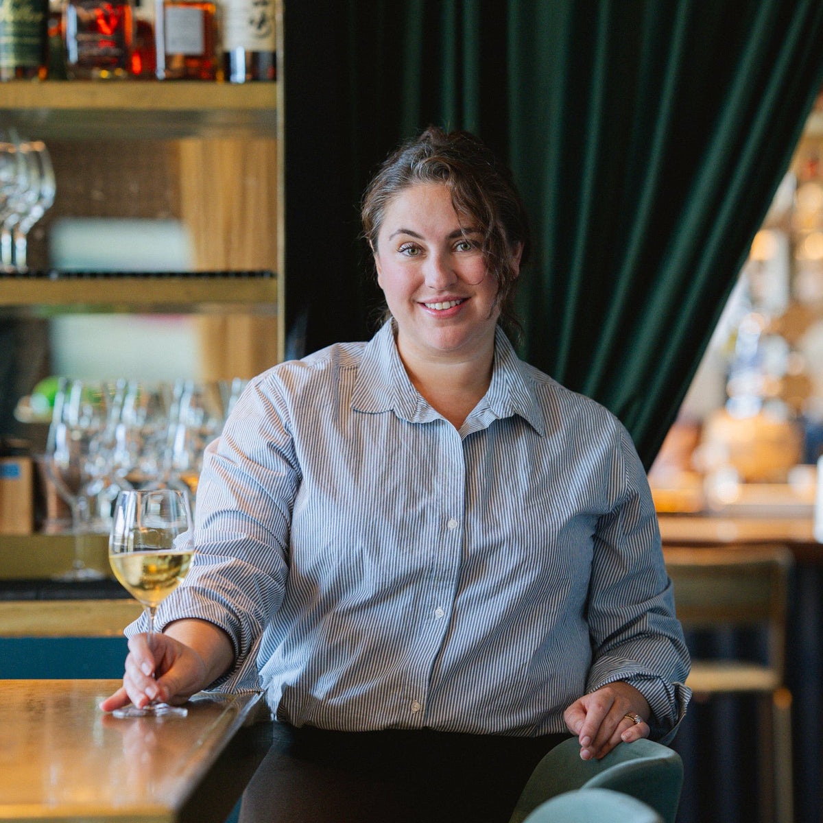 photo of Sarah MacIsaac holding a glass of wine